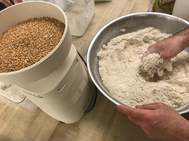 tabletop mill with grains and freshly milled flour