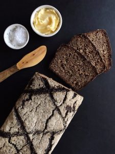 Vollkornbrot loaf with spreading knife, butter, and salt