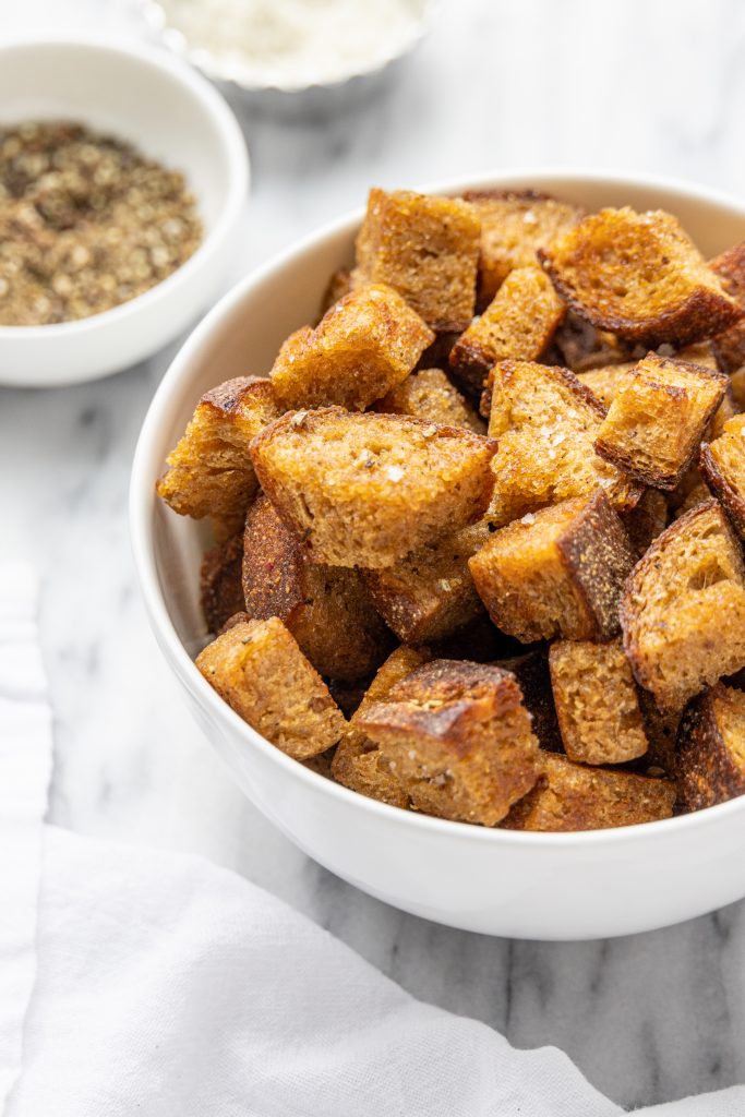 croutons in a white bowl on a marble table