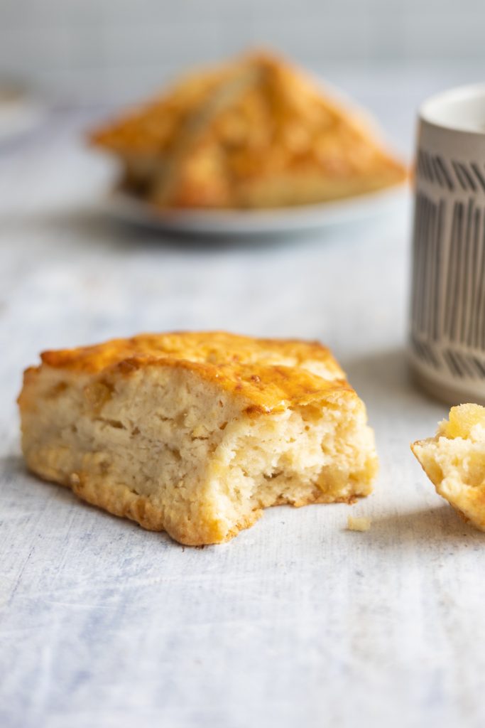 ginger scone with one bite off to the side and a mug 