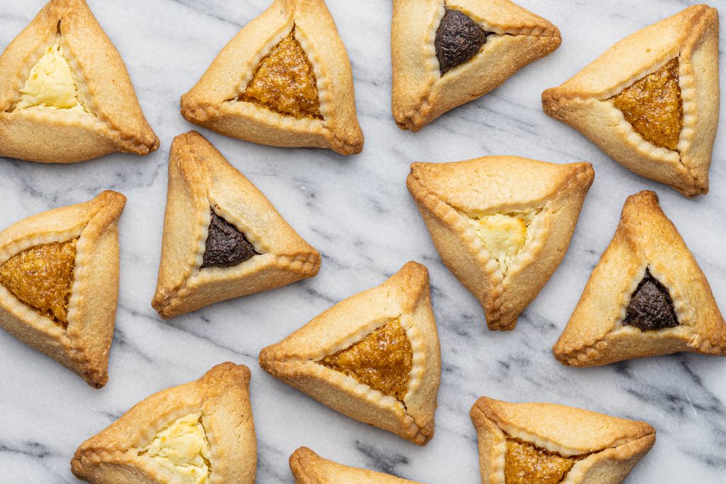 overhead view of a selection of hamantaschen on a marble surface