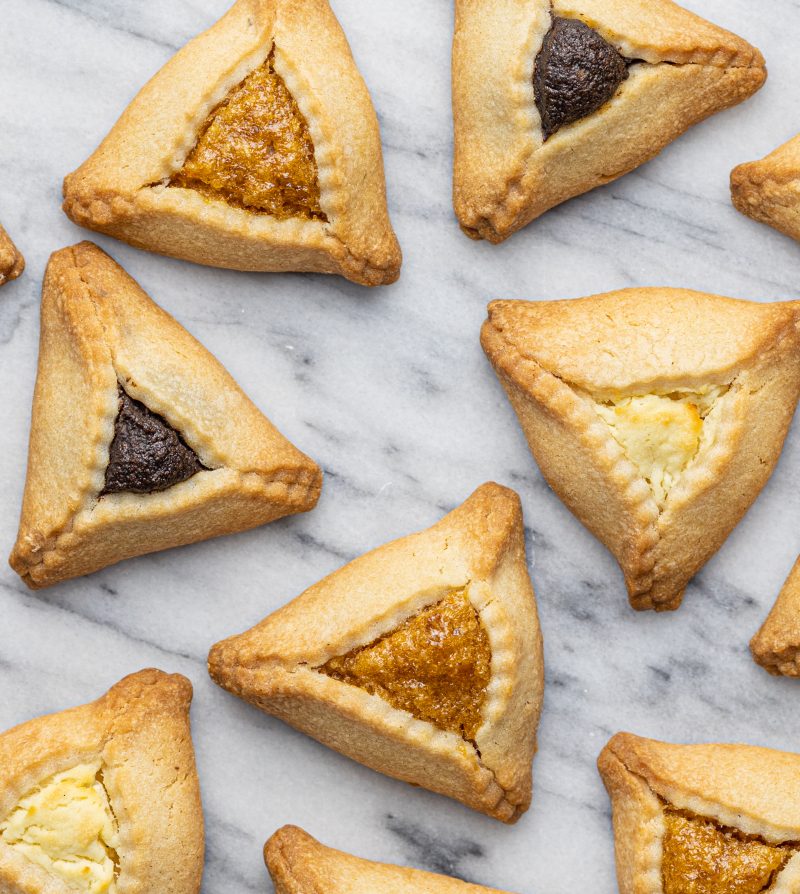 overhead view of a selection of hamantaschen on a marble surface