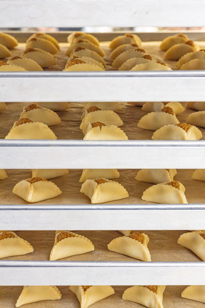 sheets of hamantaschen on a speed rack