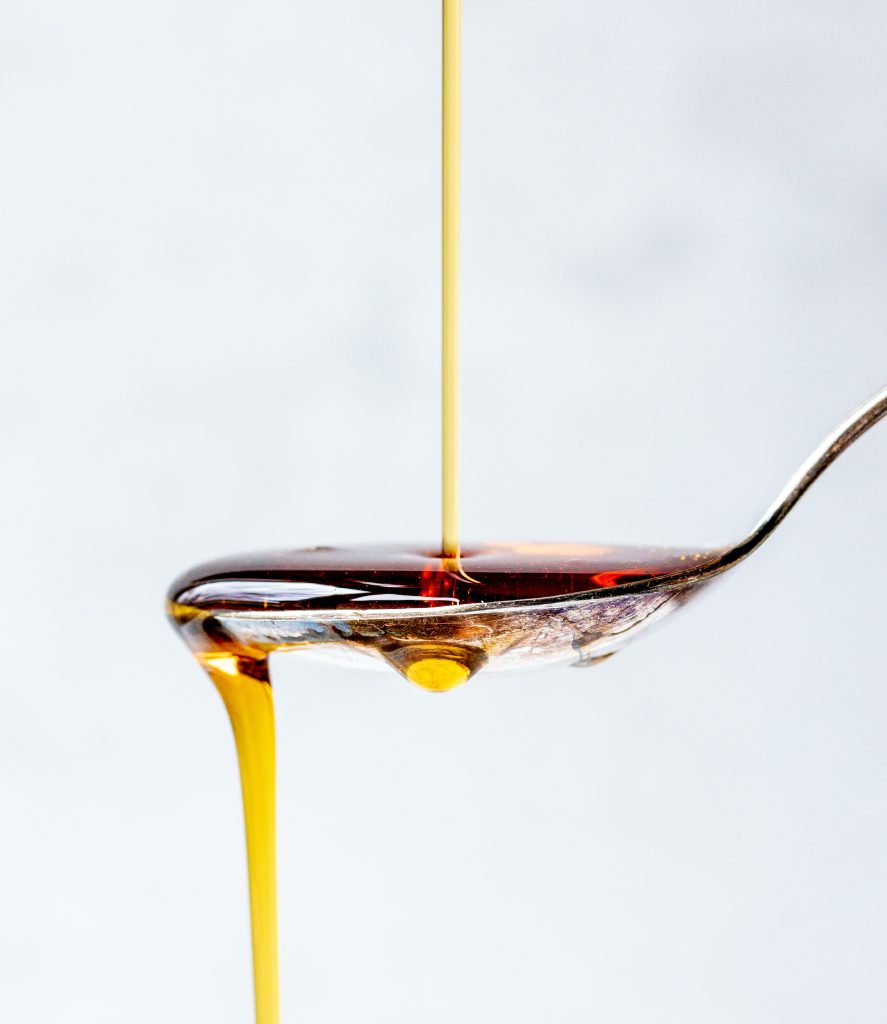maple syrup streaming onto a spoon and pouring off