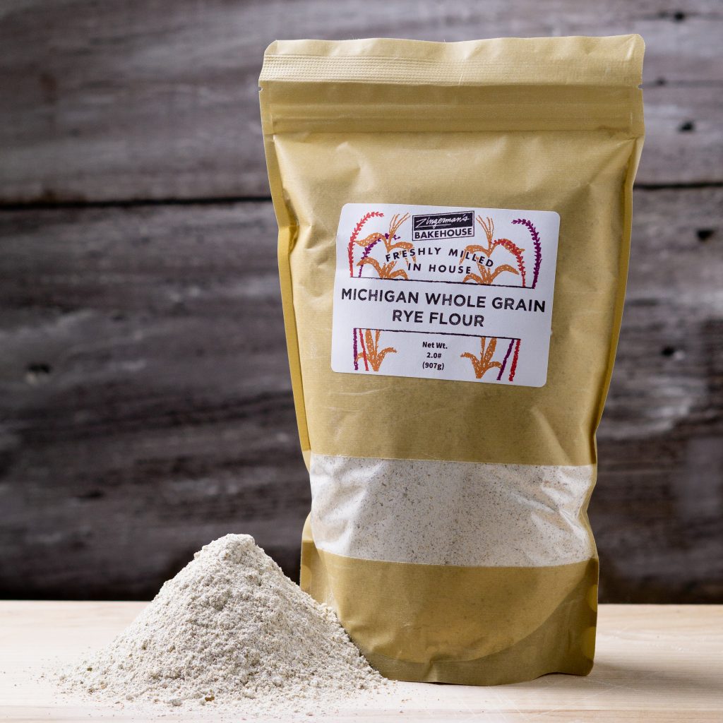 a bag of michigan whole rye flour with a pile of rye flour in front of it