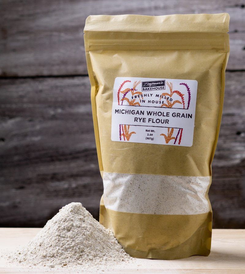 a bag of michigan whole rye flour with a pile of rye flour in front of it