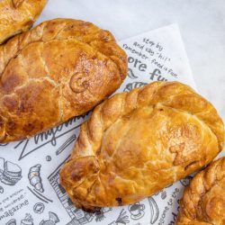 4 Cornish pasties lined up diagonally on a black and white quick sheet