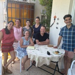 a group of people studying Sephardic cuisine sit and stand around a table in Istanbul, Turkey