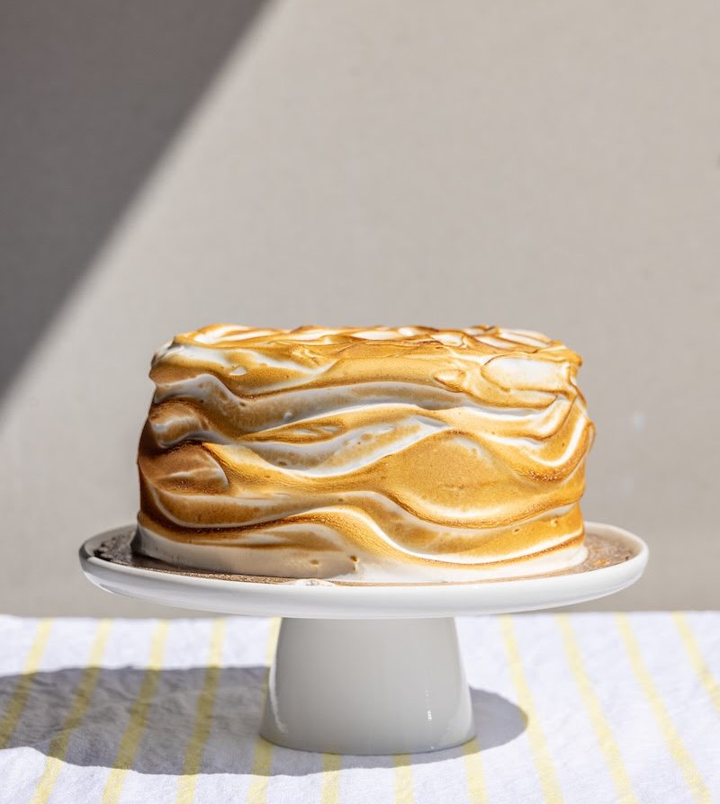 lemon sponge cake on a white cake stand
