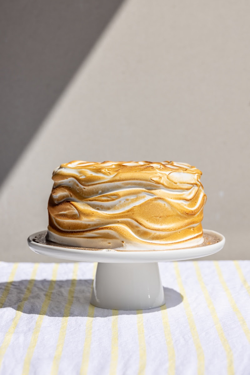 lemon sponge cake on a white cake stand