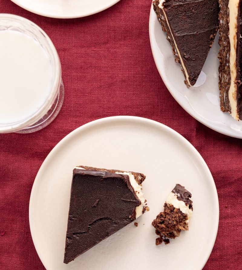 nanaimo bars on dessert plates on a red table cloth